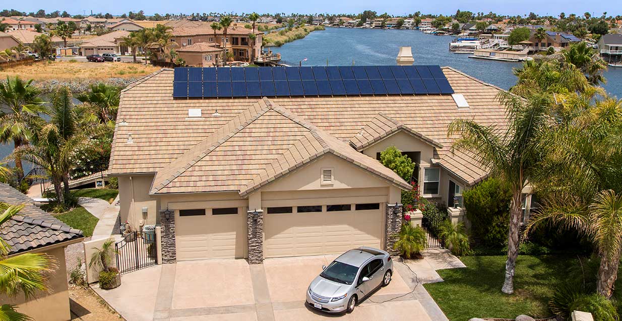 Home with a SunPower solar installation located in Phoenix Arizona. Electric vehicle parked outside plugged into a level 1 charger. 